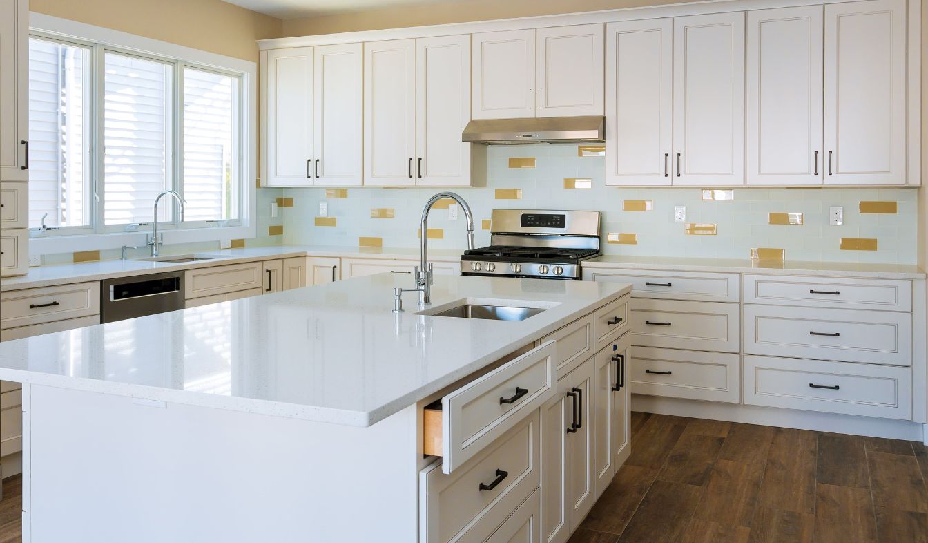 What Are The Benefits of Kitchen Remodeling? Installer fitting cabinets and a countertop in a white kitchen