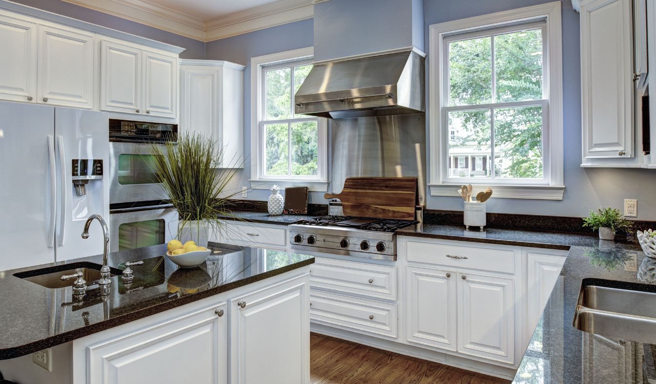 What Are The Benefits of Kitchen Remodeling? Remodeled open-plan kitchen with granite countertops and an island