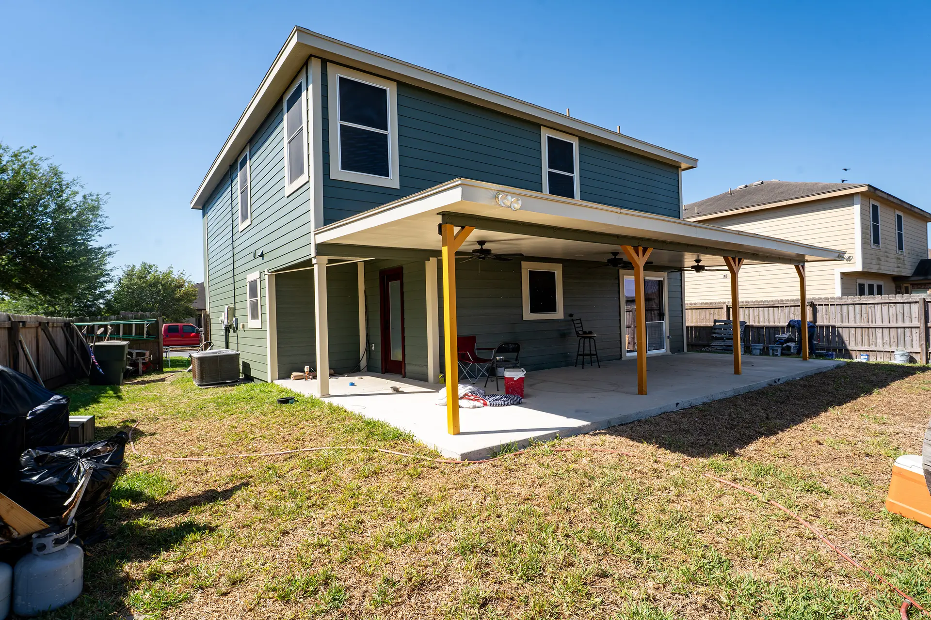 Blue-gray two-story home with a covered back patio after exterior painting