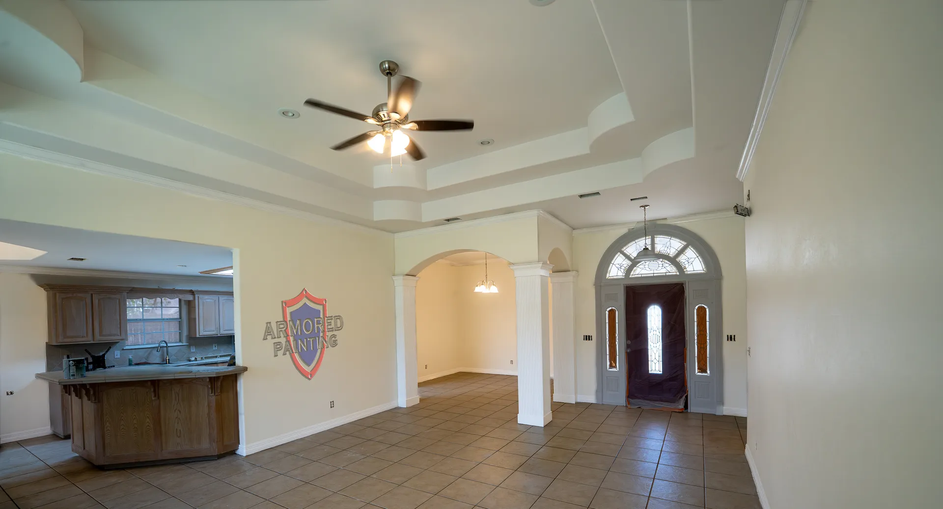 Freshly repainted open-concept living room and entry with tray ceiling